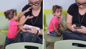 Den lille pige henvender sig til sin mor, men moren ignorerer hende, for hun er 